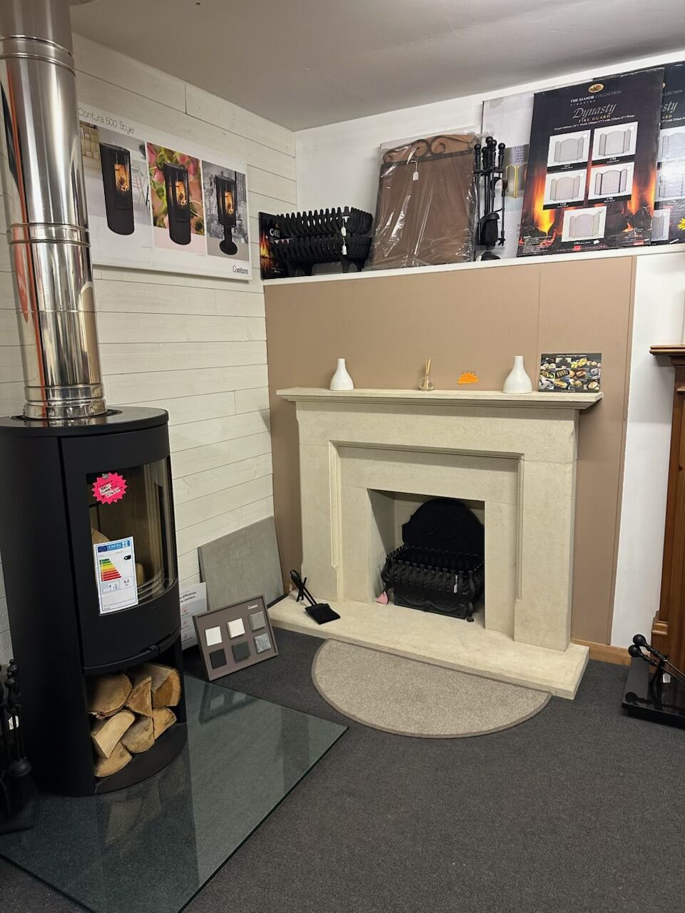 Black cylindrical stove beside a cream stone fireplace